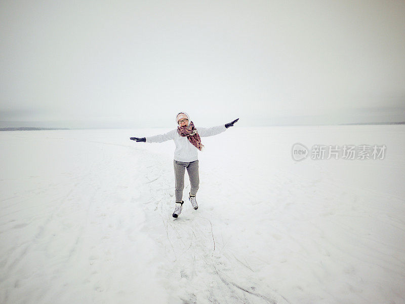 年轻女子在结冰的湖面上快乐地滑冰