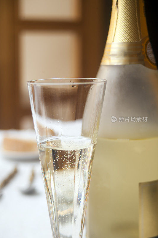 香槟瓶和香槟笛，白葡萄酒在酒杯。