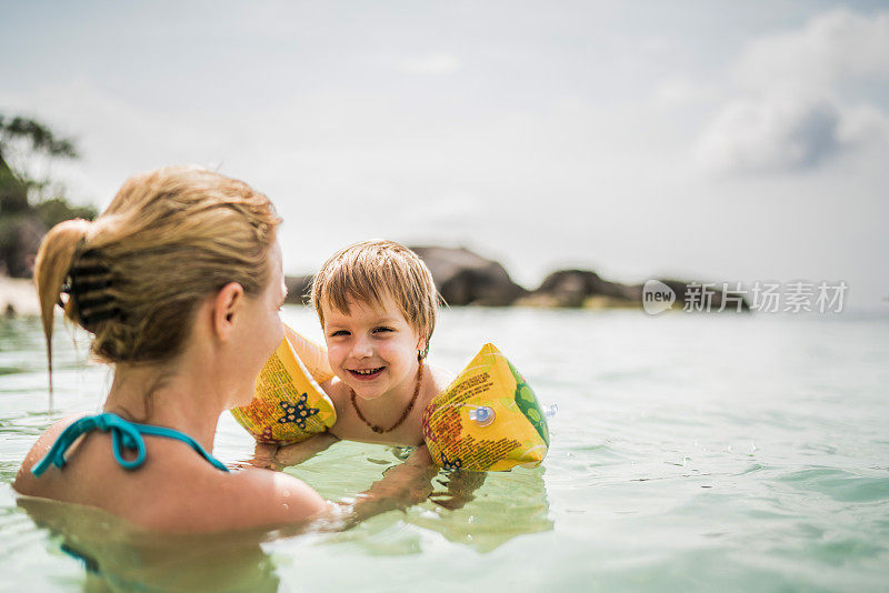 暑假里，快乐的男孩和妈妈在海边玩。