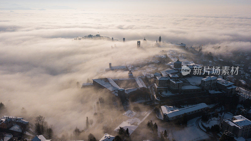 意大利贝加莫。无人机鸟瞰图，令人惊叹的景观雾从平原升起，覆盖老城