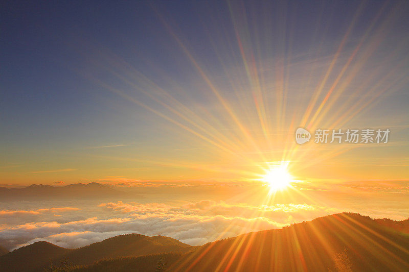 清晨的太阳笼罩在山那边的低云之上