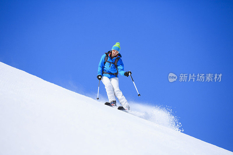 冬季运动女子滑雪者在阳光明媚的滑雪胜地滑雪