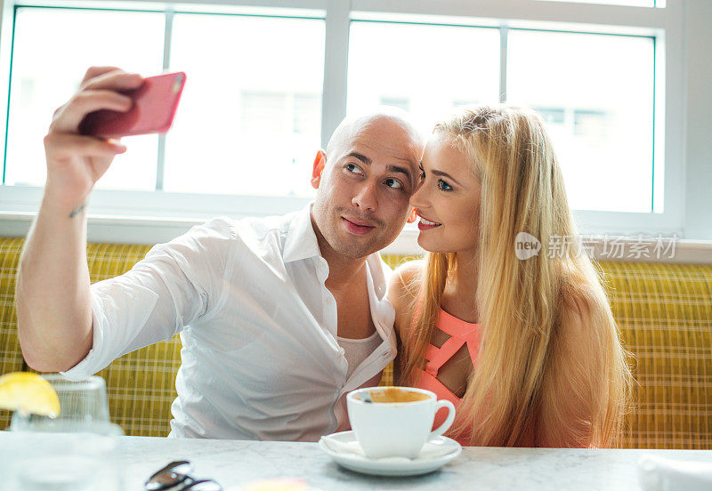 一对年轻漂亮的情侣在咖啡馆自拍