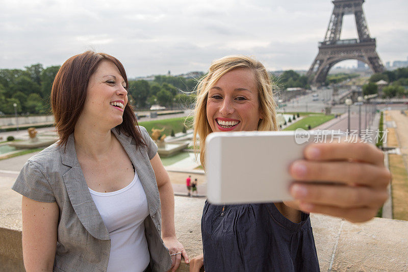 两个年轻的女游客在巴黎埃菲尔铁塔自拍