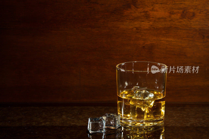玻璃桌上放着一杯威士忌