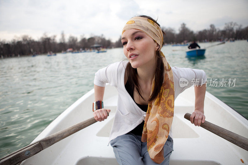 年轻美丽的女人在马德里划船