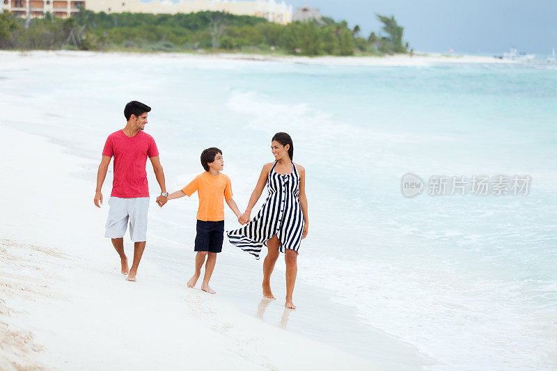 一个西班牙家庭在海滩上散步