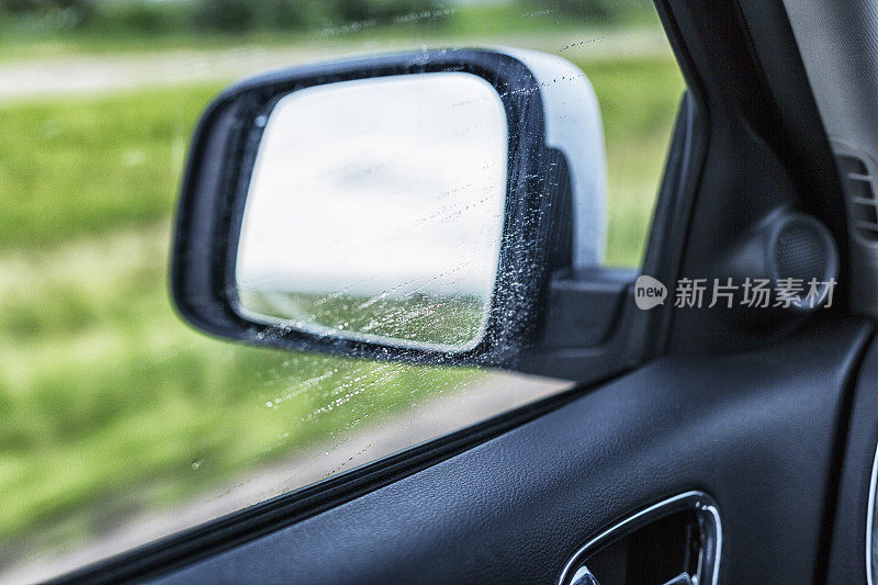 高速行驶的汽车司机侧窗上的雨点