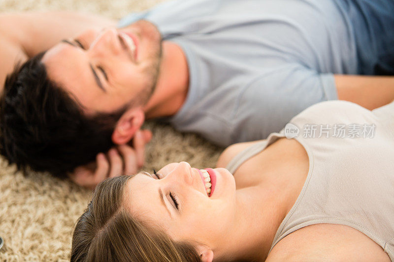 一对年轻夫妇躺在地板上
