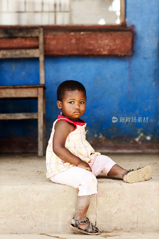 小非洲女孩坐在外面