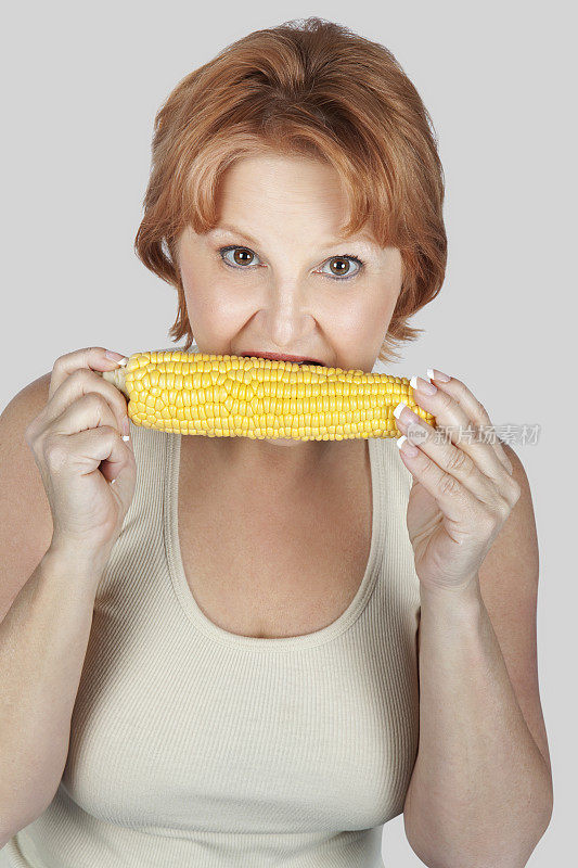 吃玉米的中年妇女