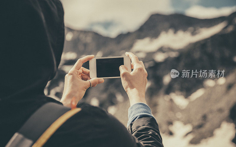 旅行者在山里用智能手机自拍