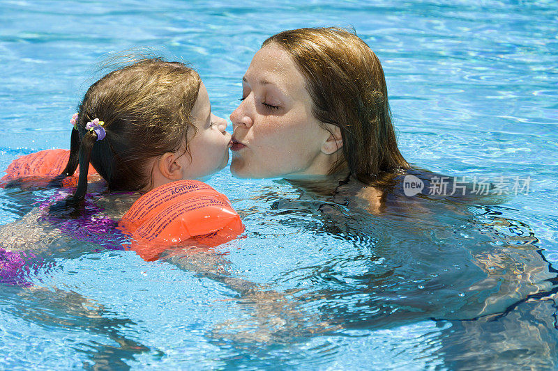妈妈和小女儿在泳池里接吻
