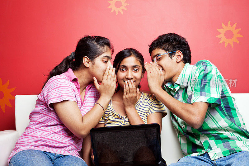 兴高采烈的印度青少年分享秘密