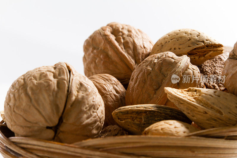 胡桃和杏仁在他们的壳在柳条篮子里。