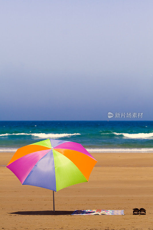 沙滩上的毛巾和雨伞。