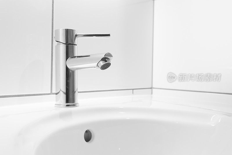 浴室里的水龙头和白色洗手盆