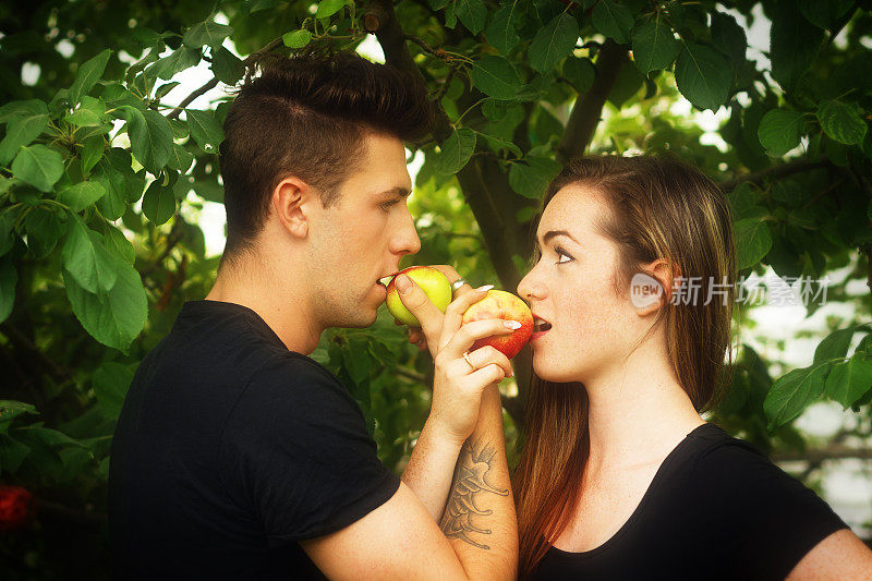 年轻夫妇看着对方，吃着苹果。