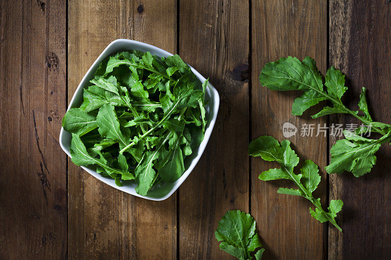 有机芝麻菜碗从乡村木桌子上方拍摄