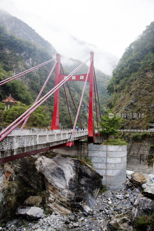 悬索桥横跨树木覆盖，雾气弥漫的山谷，台湾