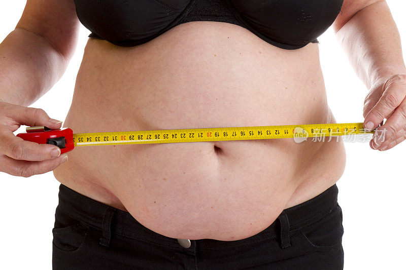 胖女人测量她的肚子。