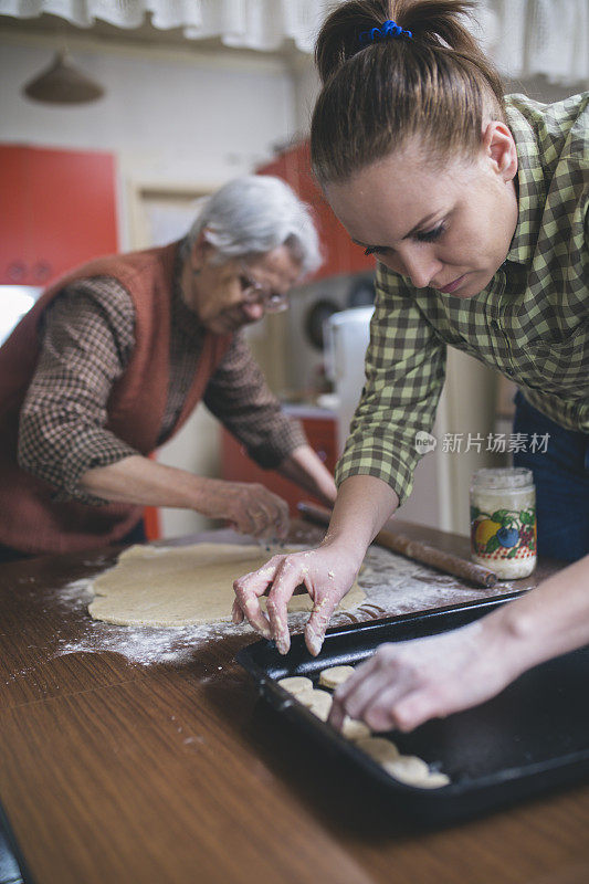 祖母和孙女烘烤饼干准备面团