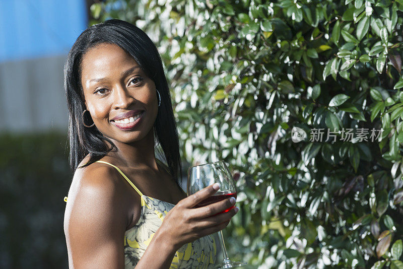 美丽的非裔美国女人微笑着，喝着酒