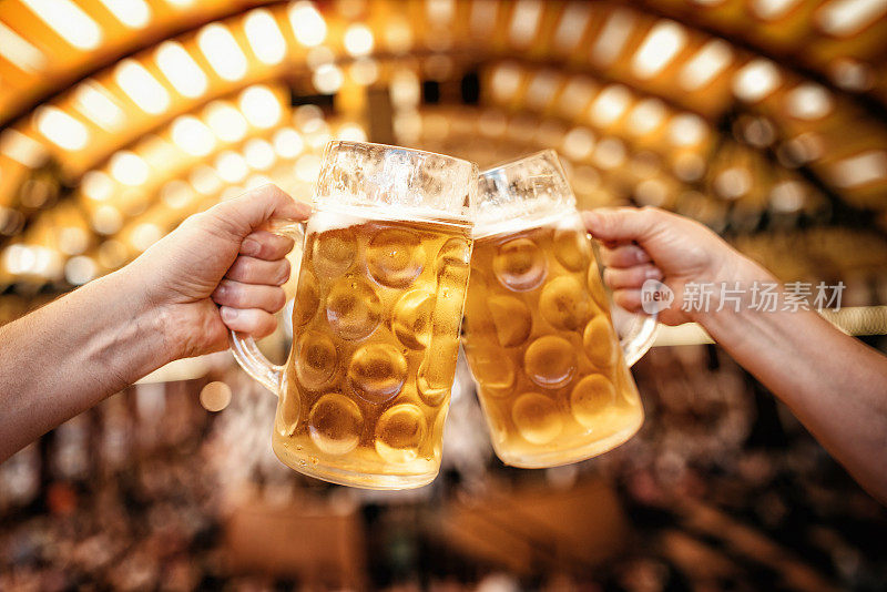在慕尼黑啤酒节上，两只手碰杯