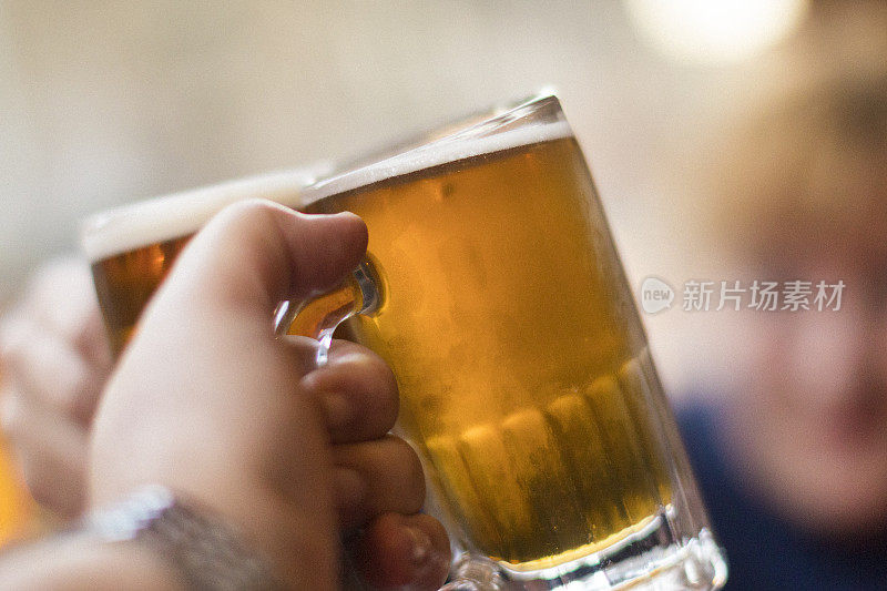 一对夫妇拿着各自的啤酒杯庆祝这个好消息，每个啤酒杯里都装着不同种类的啤酒。