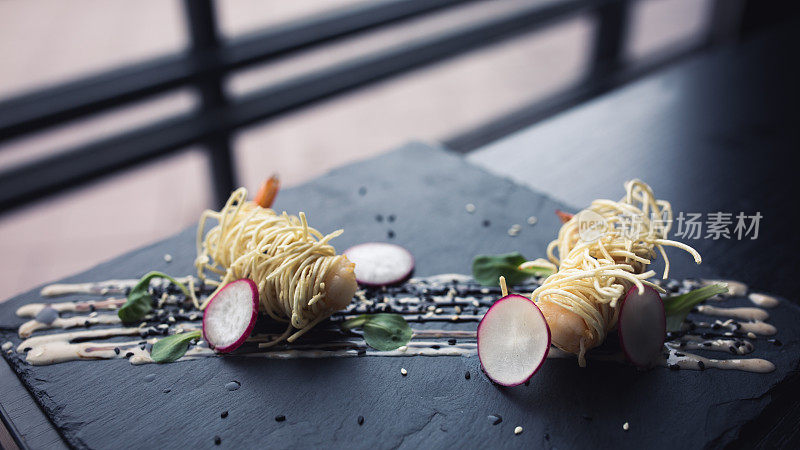 黑盘酱面虎虾。亚洲食物的背景。饮食的概念。餐厅的地方与木桌。16在9裁剪设计