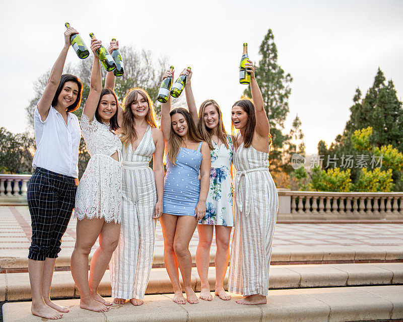 六名女大学生高举香槟酒瓶庆祝毕业