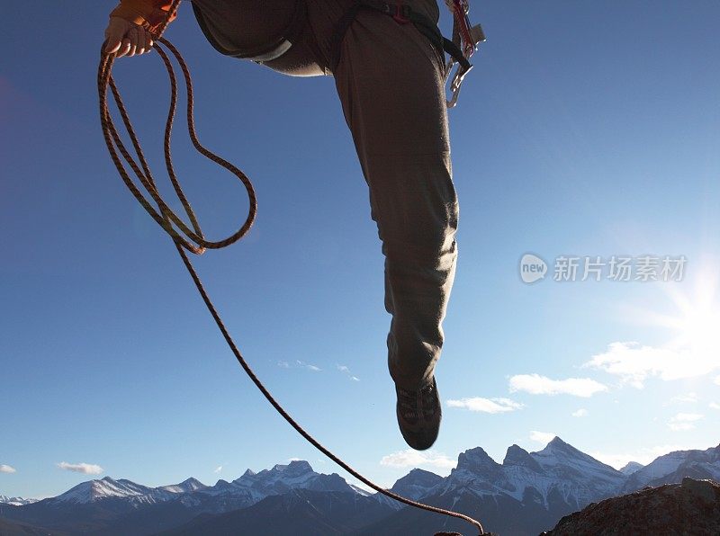 低角度视角的登山家跳跃的山与绳子