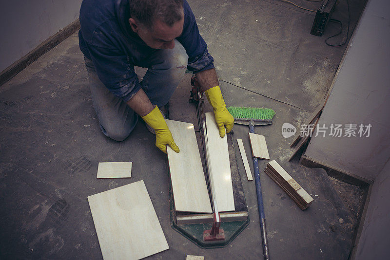 工人在测量和切割瓷砖的照片