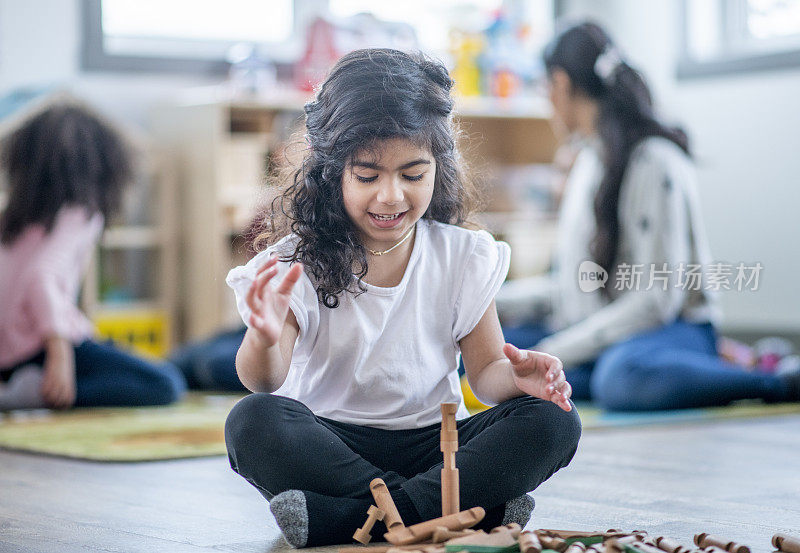 甜美的日托女孩大厦与积木库存照片