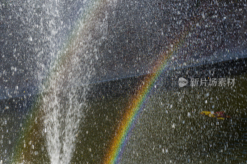 彩虹在喷水池溅起的水里