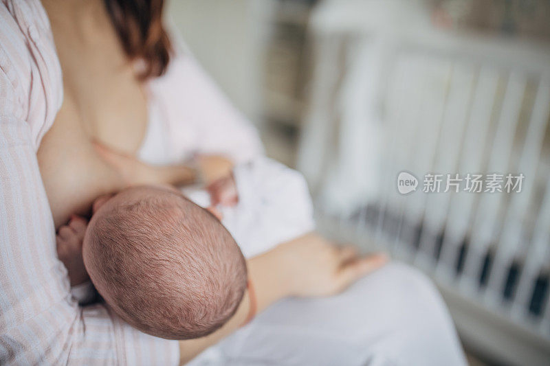 母亲在家里母乳喂养她的男婴