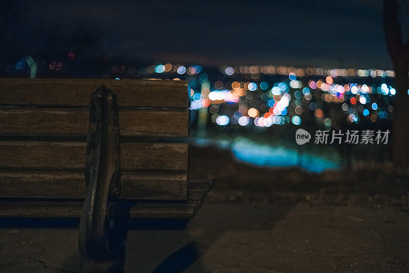 夜晚俯瞰城市灯光的公园长椅