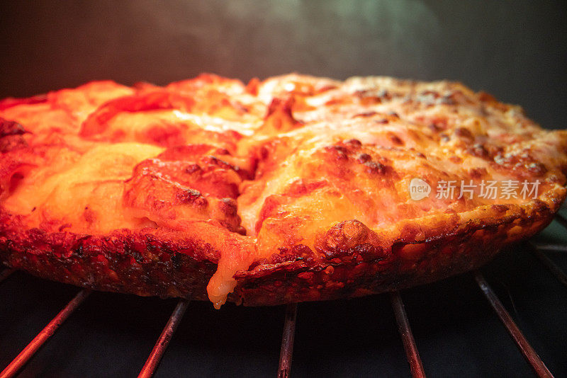 超近距离广角微距拍摄烧焦的奶酪在美味的热气腾腾的深盘皮辣香肠披萨新鲜出炉的烤箱在冷却架下加热灯与复制空间