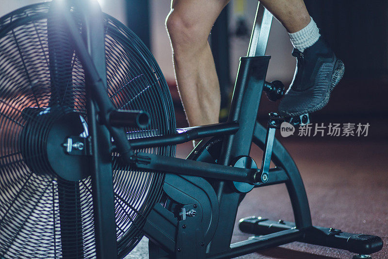 近距离拍摄的运动员在健身房骑着一辆固定自行车