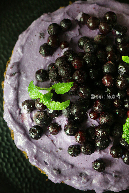 蓝莓芝士蛋糕以黄油饼干为底色，蓝莓马斯卡彭奶油芝士甜点布丁以新鲜的蓝莓和薄荷叶装饰