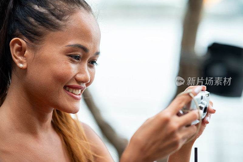 青年的赋权和健康。微笑的菲律宾女人用相机拍照的肖像