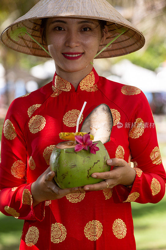 异国情调的传统越南女孩，同时提供新鲜的椰果和鲜花