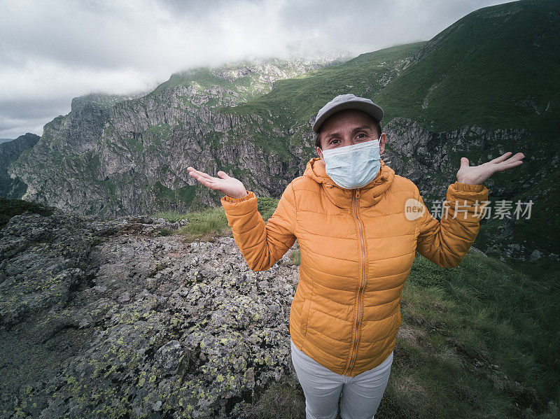 回归自然。新的标准。一个女人独自旅行者的肖像与保护性面具在她的脸上徒步在山上。2019冠状病毒病大流行期间，阳光明媚的户外享受。