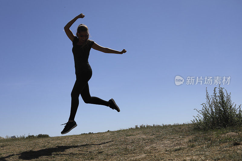 快乐和快乐，使跳跃的形状在蓝色的夏天的天空