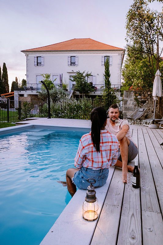 在法国阿尔代什有木制甲板和游泳池的法国度假屋。在法国南部的度假别墅豪华度假期间，夫妇放松与木制甲板的游泳池
