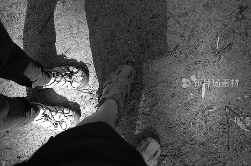 男男女女脚穿凉鞋走在沙地上