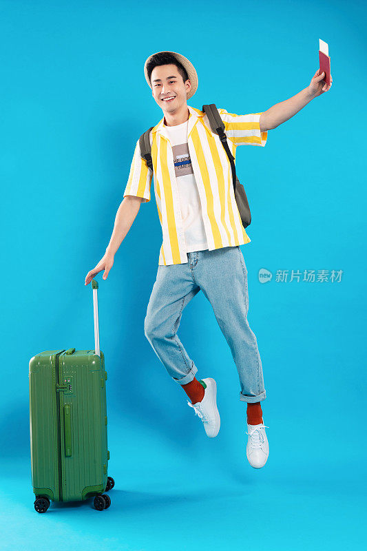 扶着行李箱跳跃的年轻男人