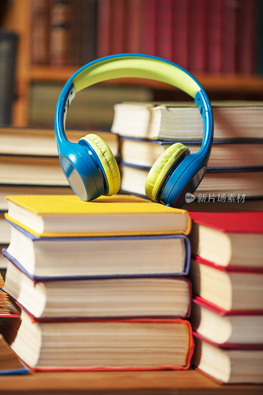 有声书概念-耳机与书籍堆叠