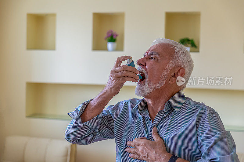 患有哮喘的老年男子有呼吸问题，所以他正在使用吸入器。