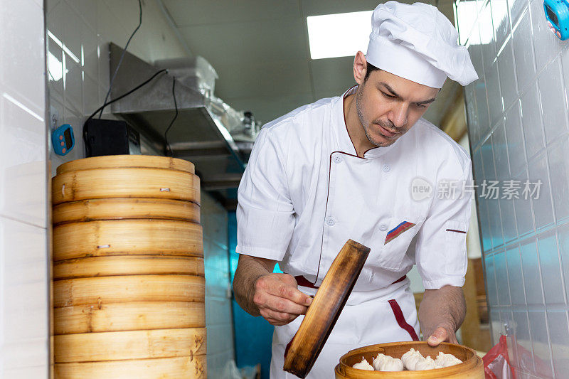 专业厨师在餐厅做新鲜饺子的肖像。